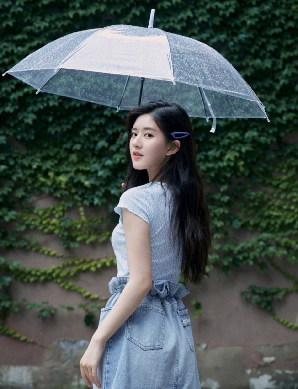 赵露思分享的一组打伞在雨中的照片,整体造型简洁具有少女风情