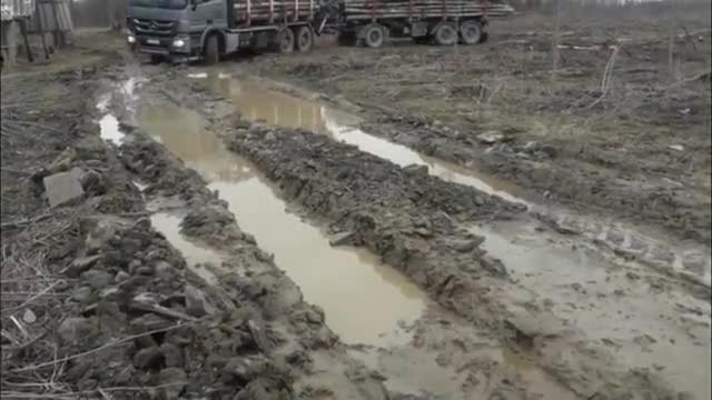 实拍：奔驰卡车满载木材走泥路，坑坑洼洼不好走