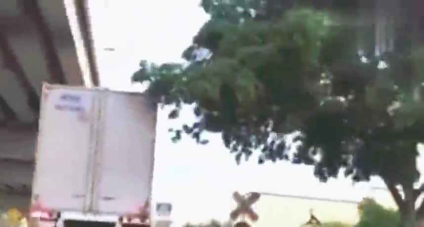 实拍大厢货车胆大的停在轨道上，遭远处驶来的火车顶出几十米