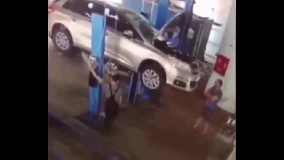 实拍汽车突然从汽修升降机上掉下来，但愿两个小伙子没事