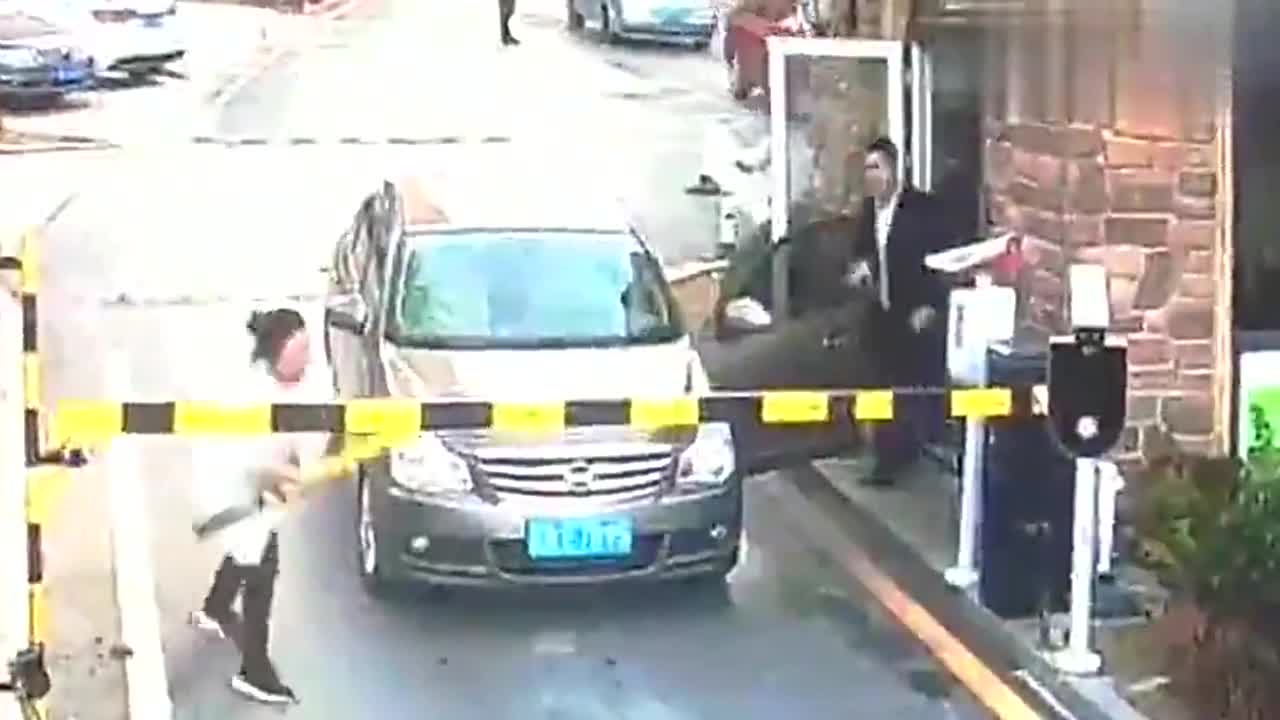 实拍女子不满物业，收取停车费出门，遭堵拦后竟砸断拦车杆