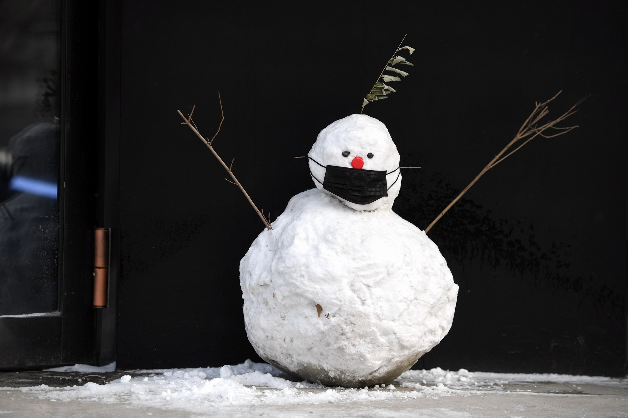 雪后孩子给雪人戴上口罩 让雪人与我们一起抗疫