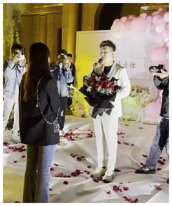 阿哲捧着一大束红玫瑰向自己的未婚妻(老婆)孙姗求婚.