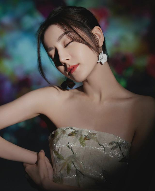 迪丽热巴曝光了一组写真,她身穿亮片抹胸长裙搭配立体花朵耳环,锁骨与