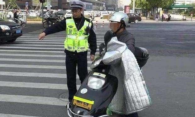 电动车装“挡风被”被交警罚50元，车主不满反问：难道只能挨冻