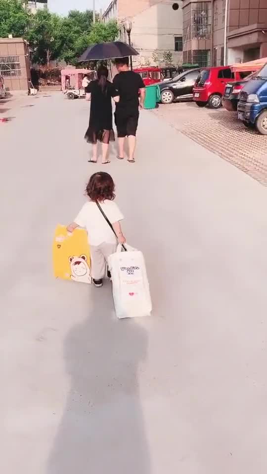 爸爸给妈妈打伞，女儿在后面提袋子，这孩子是亲生的吗