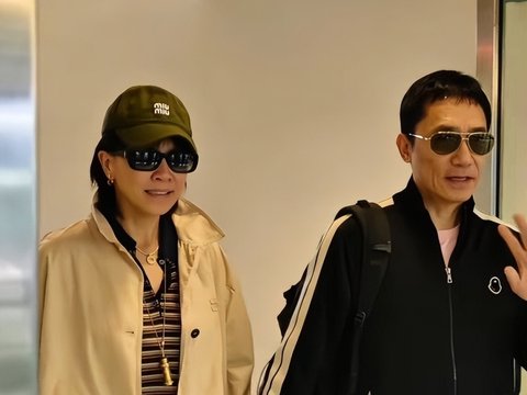 梁朝伟夫妇牵手现身机场,两人十指紧扣,刘嘉玲优雅从容,梁朝伟像个腼腆大男孩