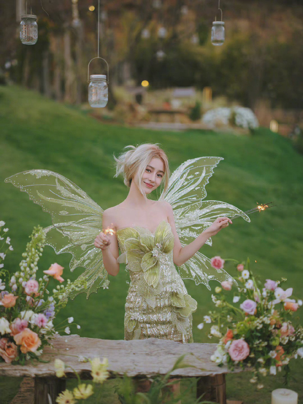 angelababy身穿绿色闪光裙搭配翅膀造型,置身草坪之上,好似精灵少女!