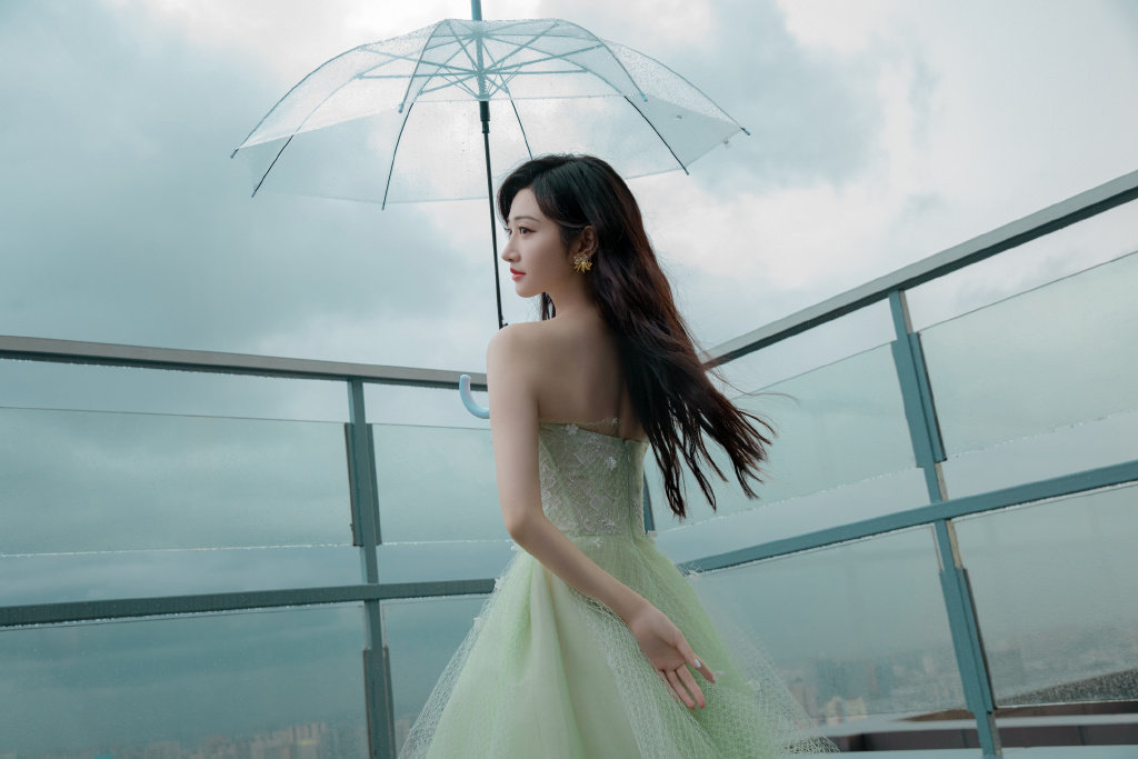 景甜身穿薄荷绿纱裙在雨中漫步撑伞氛围感满分
