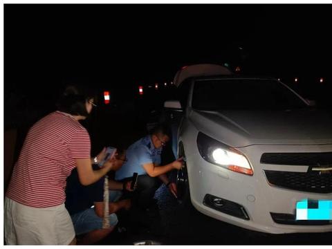 雨夜游客车辆爆胎抛锚，民警暖心帮助更换备胎