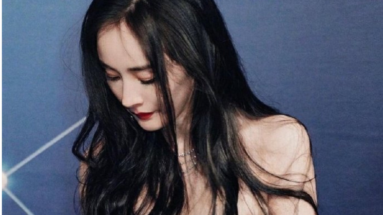 杨幂身穿黑色抹胸皮裙，画着精致的妆容，红唇衬托出肌肤雪白