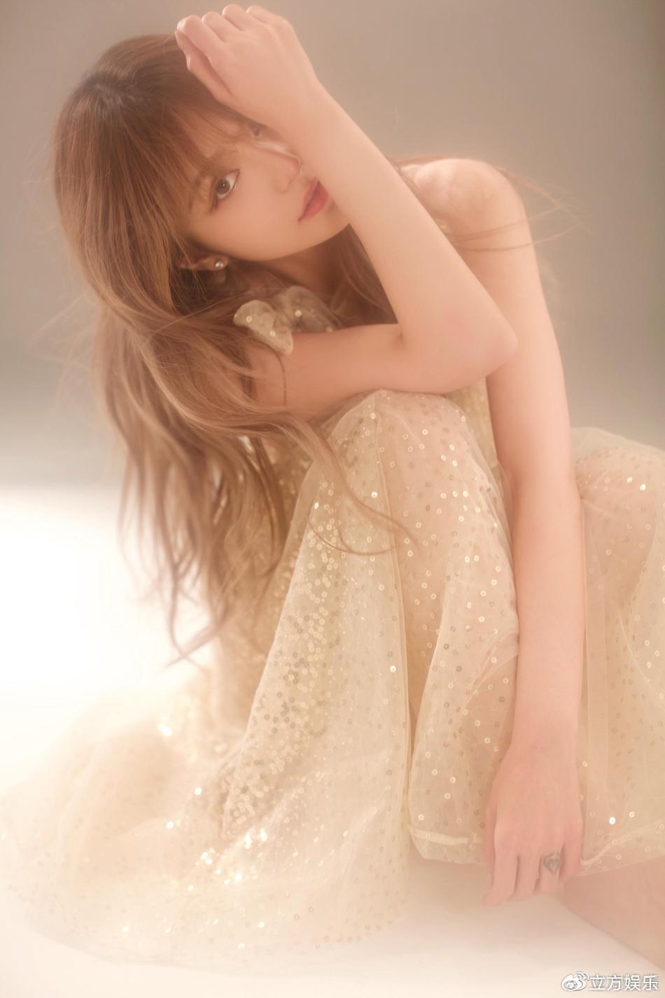 周扬青穿着香槟色亮片纱裙，披着微卷长发甜笑，状态很好
