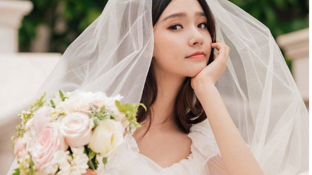 林允身穿白色婚纱，一头长发，手臂纤细，皮肤白皙，配上精致的妆容