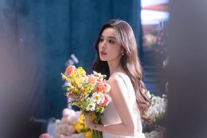 娜扎穿白色亮片裙转身回眸，手捧花束笑容自然