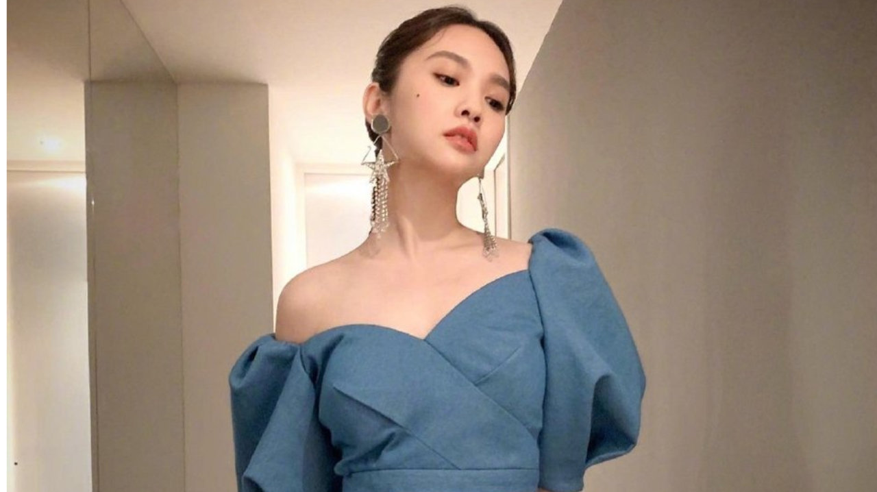 杨丞琳身着蓝色短款单肩上衣，大秀香肩蛮腰