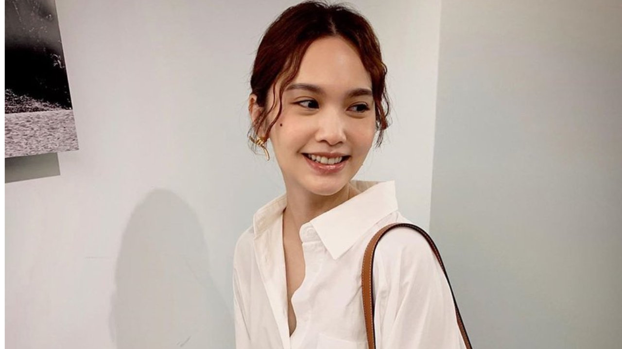 杨丞琳身穿白色衬衫搭配牛仔裤文青范十足，对着镜头甜笑，元气满满。