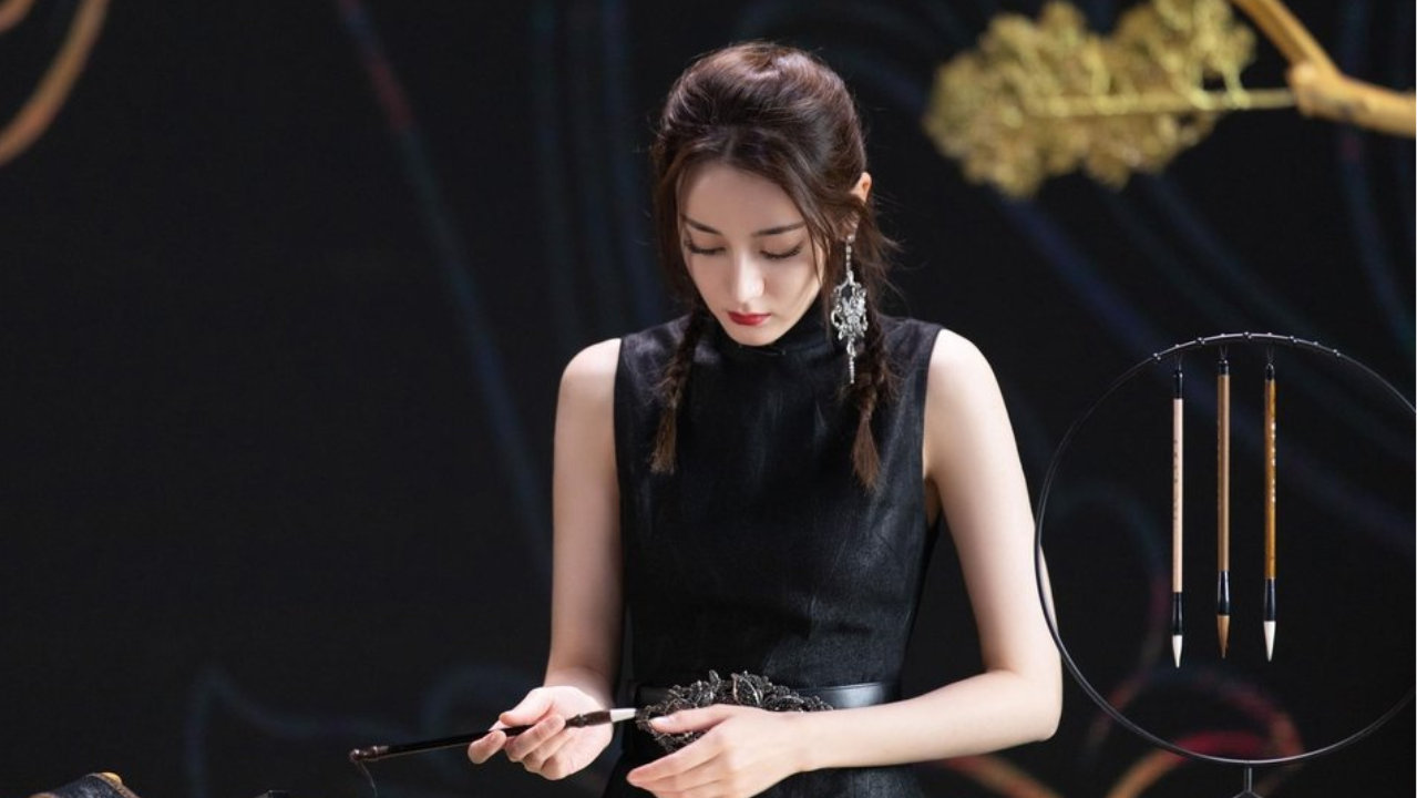 迪丽热巴身穿黑色旗袍端庄典雅，戴着单边蝴蝶耳饰精致时尚