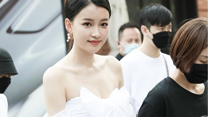 孙怡穿着白色露肩上衣搭配热裤，露出美背和大长腿十分撩人，笑容甜美