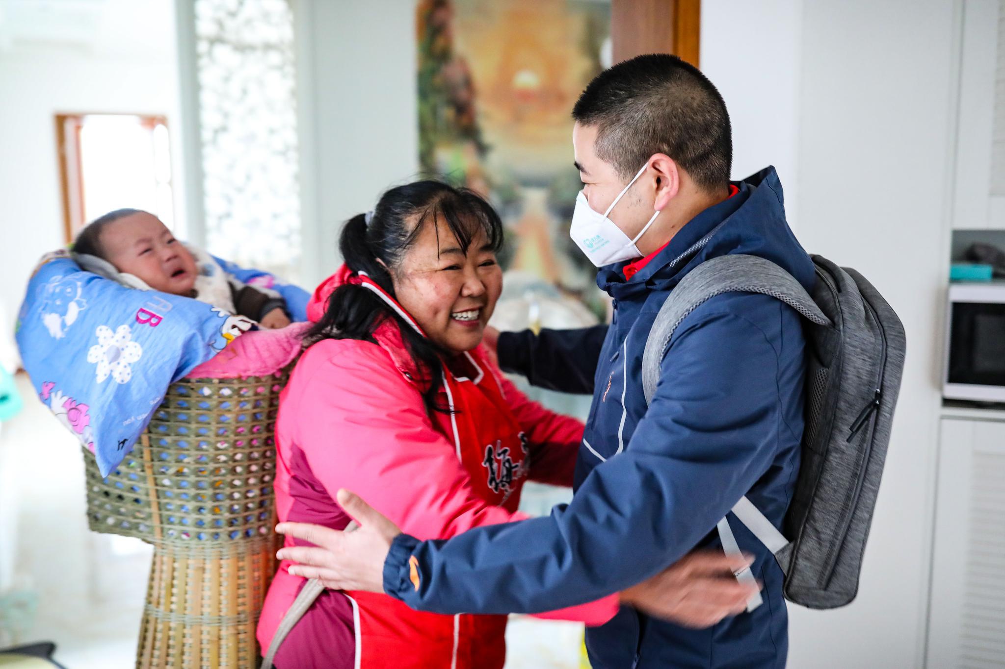 新华社记者 欧东衢 摄↑4月1日,李董江(左)在所住的小区内帮妻子刘凌