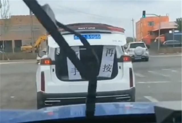 后车按喇叭催促前车,前车升起“对联”解释,网友:真是个人才