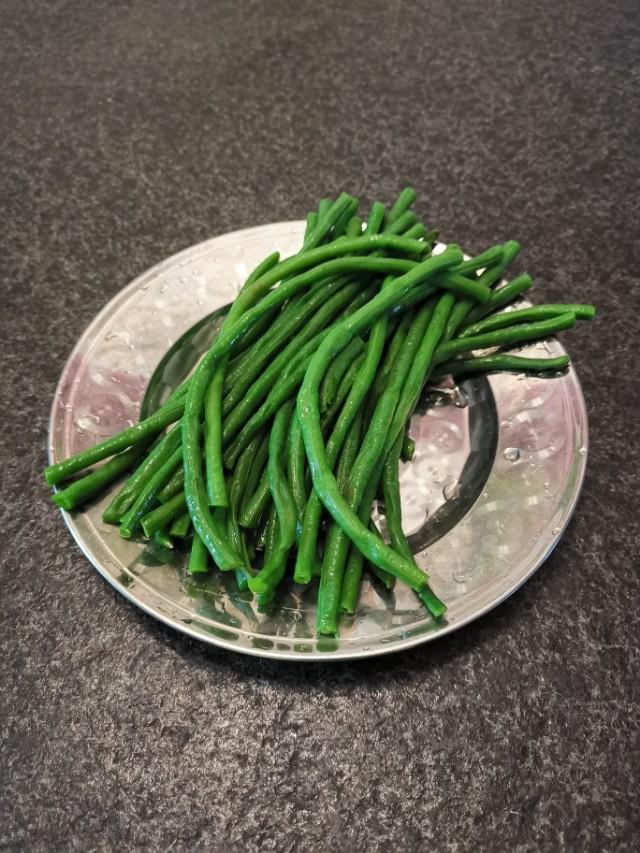将豆角中加入胡萝卜和面粉做成小窝窝,蒸熟后蘸着美味的蒜末鸡蛋泥