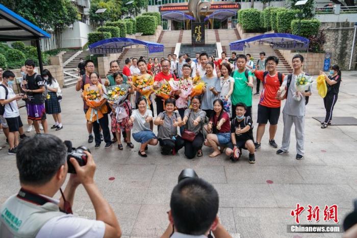 7月8日下午,广西南宁二中新民校区考点,高考英语科目考试结束后,老师与考生在考场外合影留念。 中新社记者 陈冠言 摄