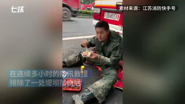 排除险情后坐路边吃饭,抗洪消防员手捧盒饭睡着了