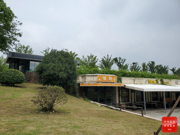 连日来,受长江大流量来水和强降雨影响,秦淮河水位居高不下,南京市一度启动防汛一级应急相应。而就在江宁区杨家圩市民公园旁的秦淮河大堤上,却有几家无计划审批手续的违建餐厅仍在业务。图为7月25日仍在业务的餐厅。任梦岩 摄