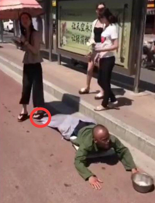 公交车站台爬来了一名乞丐,女子看出端疑,当场下去踩了他一脚
