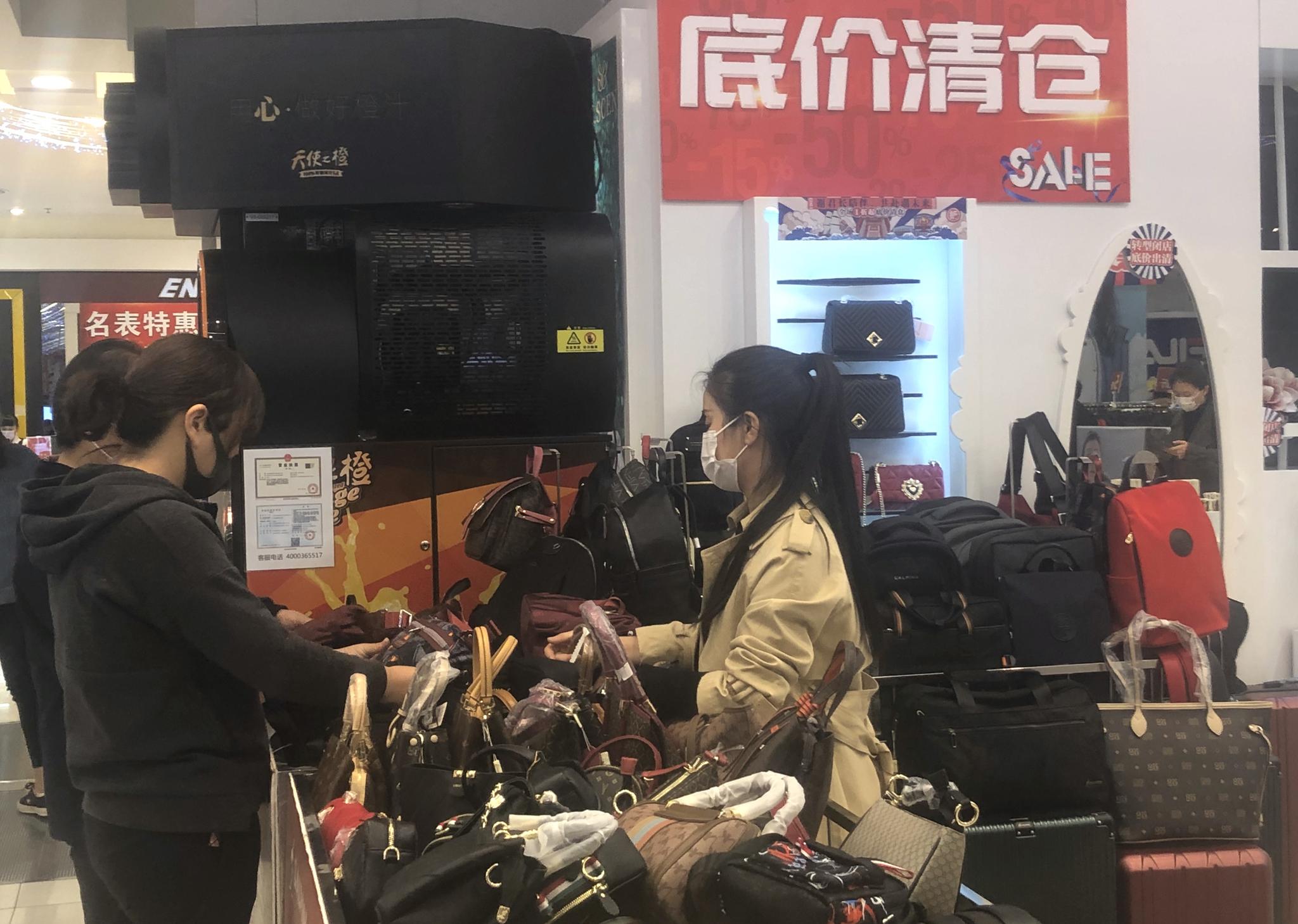 东安市场,一位主顾正在皮包柜台挑选商品。拍照/新京报记者 吴宁