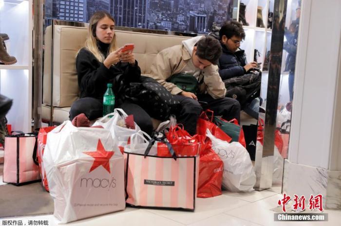 资料图：当地时间2019年11月28日，一年一度的“黑色星期五”促销日到来，美国纽约大批民众购物赶至梅西百货开启“买买买”时刻。