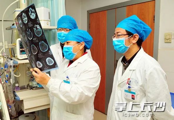 主任医师谭红(中)及精神科医生正在查看患者的头部ct片.由医院供图