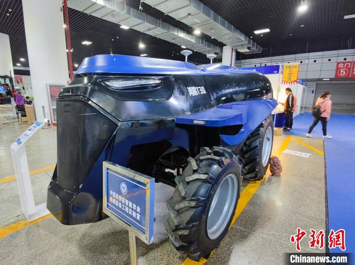 图为“一带一路”(洛阳)国际农业合作博览会上,展出的多用途智能新能源轮式拖拉机,可进行耕、耙、播、收等作业。 阚力 摄