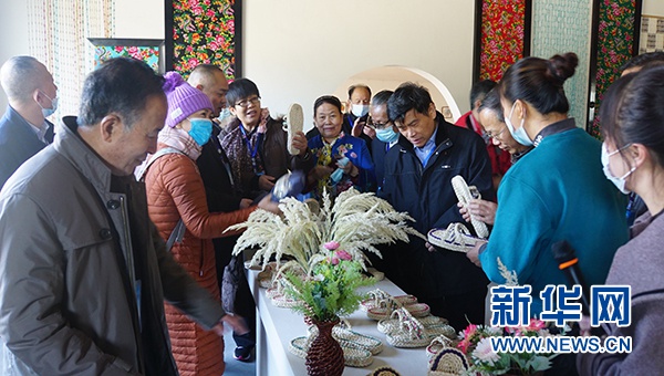 区内外的民间文艺家在冒万学民俗产业园参观草编作品。