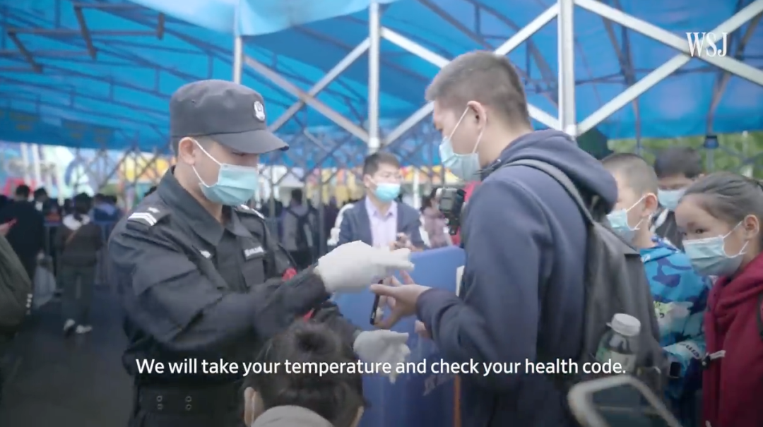 ▲工作人员在游客进入旅游场所前测体温、查验健康码,《华尔街日报》报道截图。
