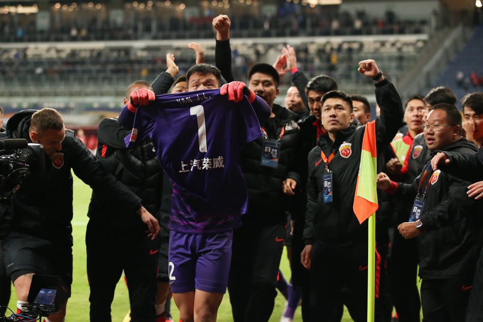 陈威举着颜骏凌的球衣庆祝胜利。