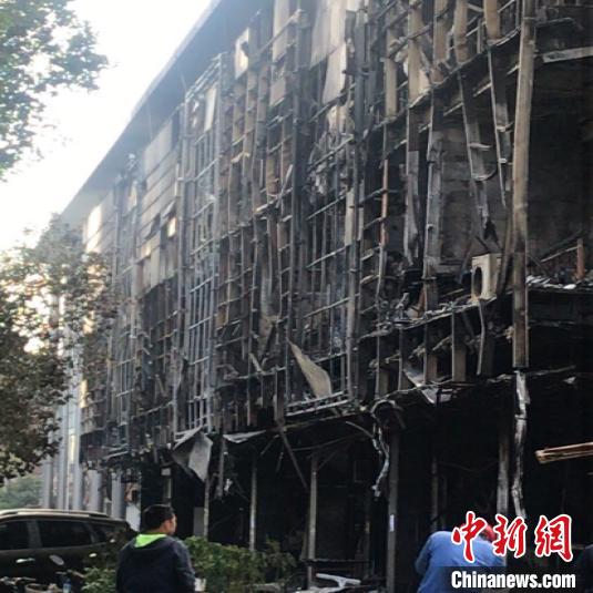 火势引燃周边商店,整栋楼被烧的面目全非。唐娟 摄