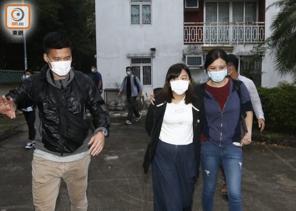 何忻诺(前排中)被押离居所 图片来源:东网