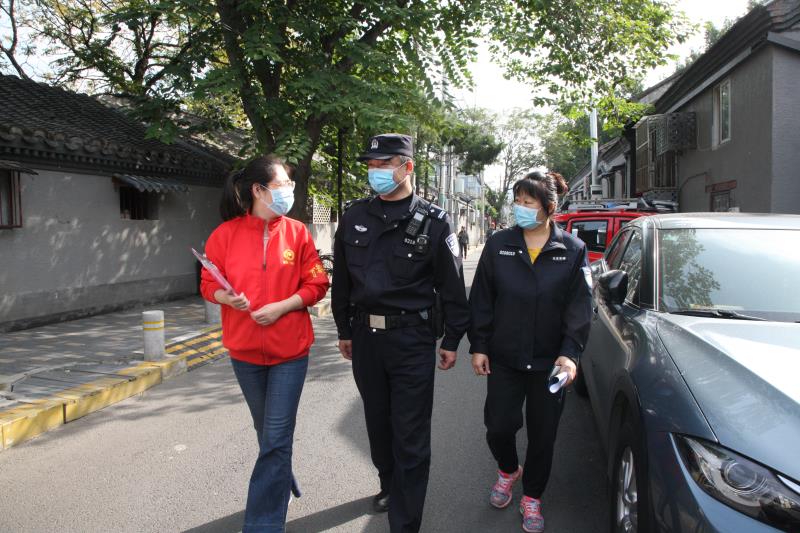 金宝街北社区民警白艳滨与同事在胡同里走访。新京报记者 王飞 摄
