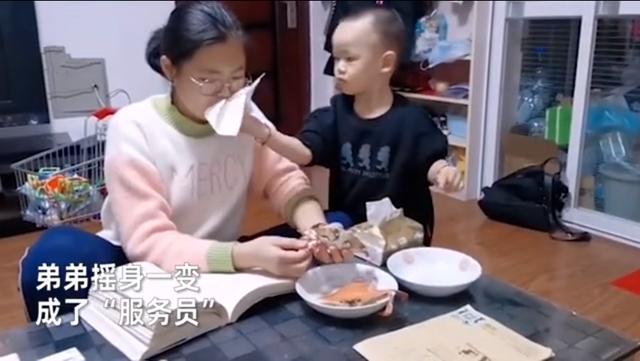 姐姐递螃蟹给弟弟，弟弟接来吃却遇眼神拷问，机智秒变“服务员”