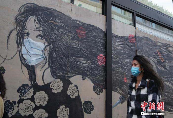 当地时间11月21日,美国加州旧金山市民戴口罩出行。中新社记者 刘关关 摄