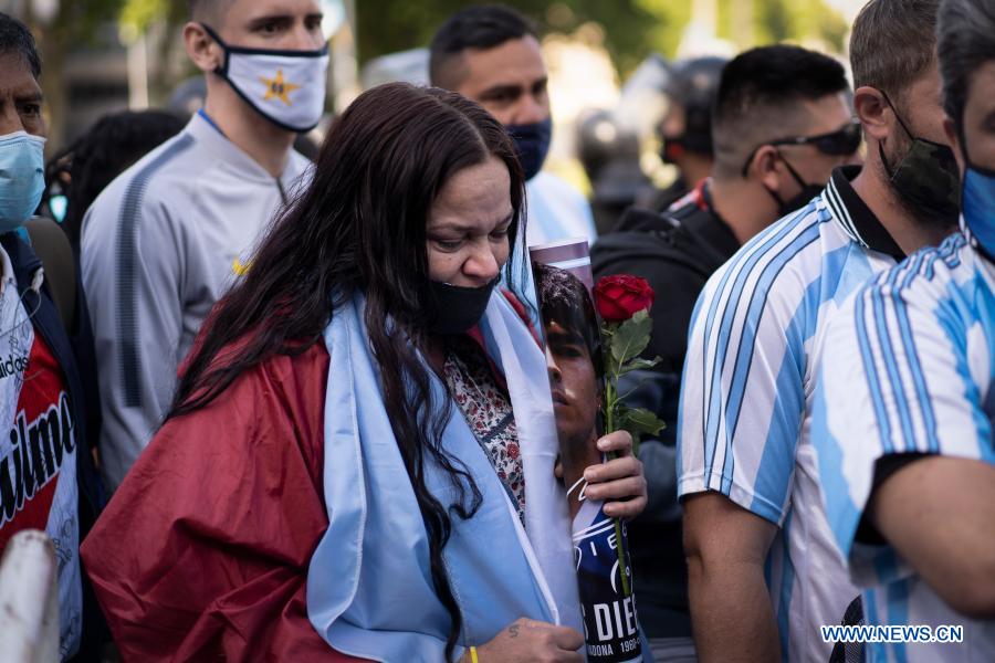 BUENOS AIRES, Nov. 26 (Xinhua) -- Thousands of people bid farewell to the late football great Diego Maradona on Thursday, as his remains were laid in state at the presidential headquarters of Casa Rosada in Buenos Aires.Many fans cried, some applauded and others left tokens of gratitude as they filed past Maradona's coffin after waiting patiently in long lines to enter the building, which opened at 6 a.m. local time for a ceremony expected to last 10 hours.Inside Casa Rosada, most of the visitors burst into tears as they passed in front of the coffin, which was covered with the Argentine flag and two football jerseys, one belonging to the national team and the other to Boca Juniors, with his emblematic No. 10.But fans of all stripes showed up, including those of Maradona's traditional rival team, River Plate, and of Italy's Napoli, where the former footballer shone.