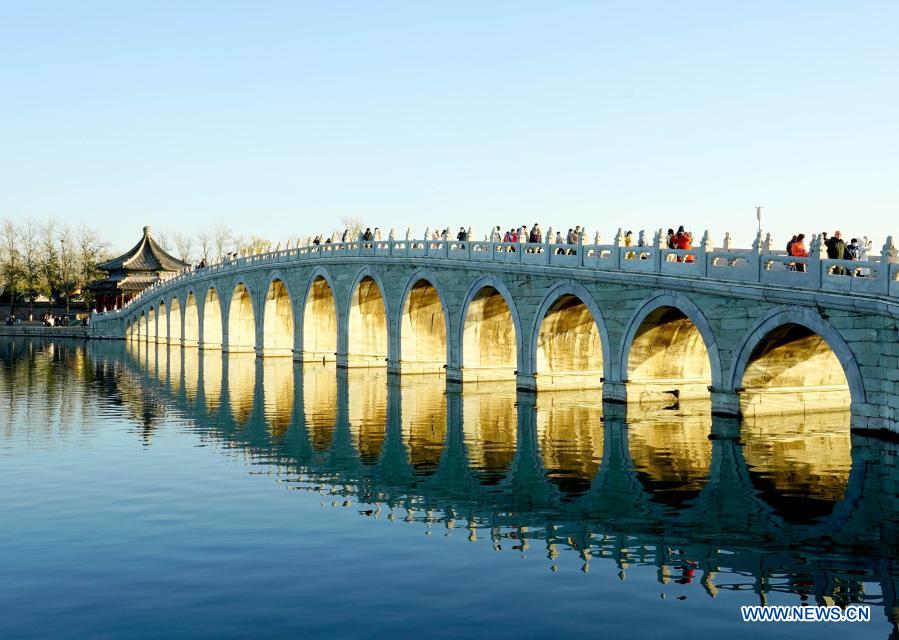 Photo taken on Nov. 28, 2020 shows the Seventeen-Arch Bridge with the sunset glow shining through its arches at the Summer Palace in Beijing, capital of China, Nov. 28, 2020. (Xinhua/Chen Jianli)
