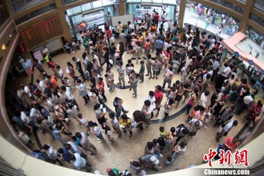 资料图:某医院挂号大厅内排起了长队。 泱波 摄