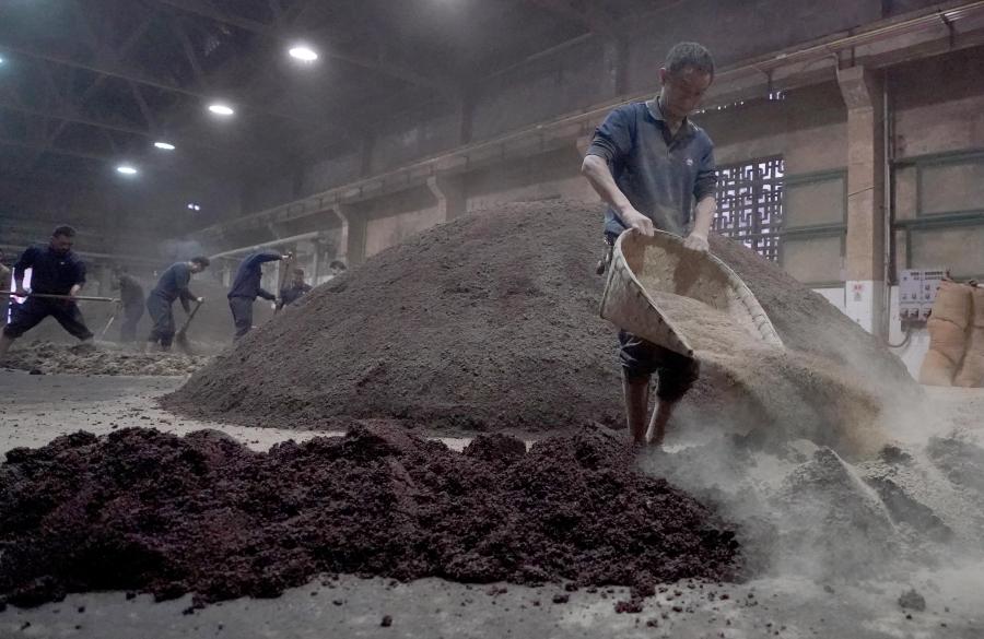 Workers mix grains with yeast at a distillery in Maotai town of Renhuai, southwest China's Guizhou Province, Nov. 28, 2020. Maotai is a small town in Renhuai City in mountainous Guizhou. What distinguishes it from other towns is that it produces a famous brand of Chinese liquor Moutai. The spirit, made from sorghum and wheat, takes up to one year for the whole production process, involving nine times of steaming, eight times of fermentation and seven times of distillation, before aged in clay pots. (Xinhua/Wang Yuguo)