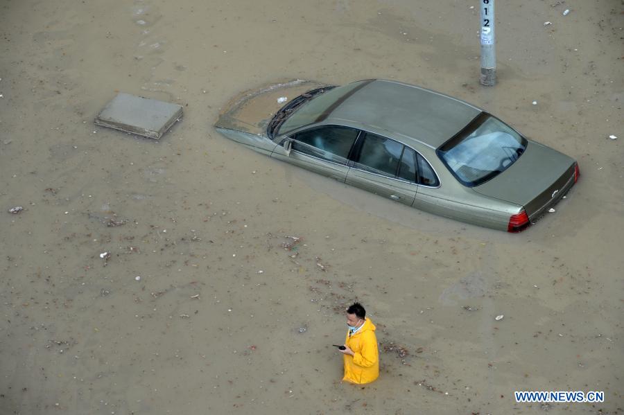 A man walks through a flooded street following heavy rains in Mubarak Al-Kabeer Governorate, Kuwait, on Nov. 29, 2020. Heavy rains hit Kuwait on Saturday evening and Sunday morning. (Photo by Asad/Xinhua)