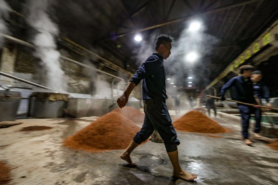 Workers moisten grains at a distillery in Maotai town of Renhuai, southwest China's Guizhou Province, Nov. 28, 2020. Maotai is a small town in Renhuai City in mountainous Guizhou. What distinguishes it from other towns is that it produces a famous brand of Chinese liquor Moutai. The spirit, made from sorghum and wheat, takes up to one year for the whole production process, involving nine times of steaming, eight times of fermentation and seven times of distillation, before aged in clay pots. (Xinhua/Ou Dongqu)