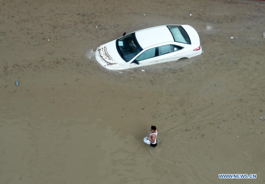 A man walks through a flooded street following heavy rains in Mubarak Al-Kabeer Governorate, Kuwait, on Nov. 29, 2020. Heavy rains hit Kuwait on Saturday evening and Sunday morning. (Photo by Asad/Xinhua)