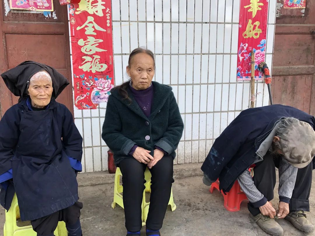 空闲的时候,德良和父母端了板凳坐在院子里,聊天、吃芭蕉,对着大山发呆。新京报记者 冯雨昕摄