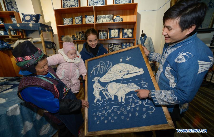 Wang Fangzhou (1st, R) explains a batik product to residents relocated from poverty-stricken areas at a batik workshop in Danzhai County of Guizhou Province in southwest China, Dec. 1, 2020. Wang Fangzhou, 40, started in August 2016 a workshop specialized in batik, a craft inherited through generations among the Miao ethnic group in Guizhou. Later on, he launched a batik experience gallery in Wanda Township, a local tourist attraction. His workshop and gallery have received more than 6,000 tourists so far this year with combined sales revenue of over 300,000 yuan (about 45,500 U.S. dollars). Thirteen residents relocated from poverty-stricken areas have found employment with decent salaries here. (Xinhua/Yang Ying)